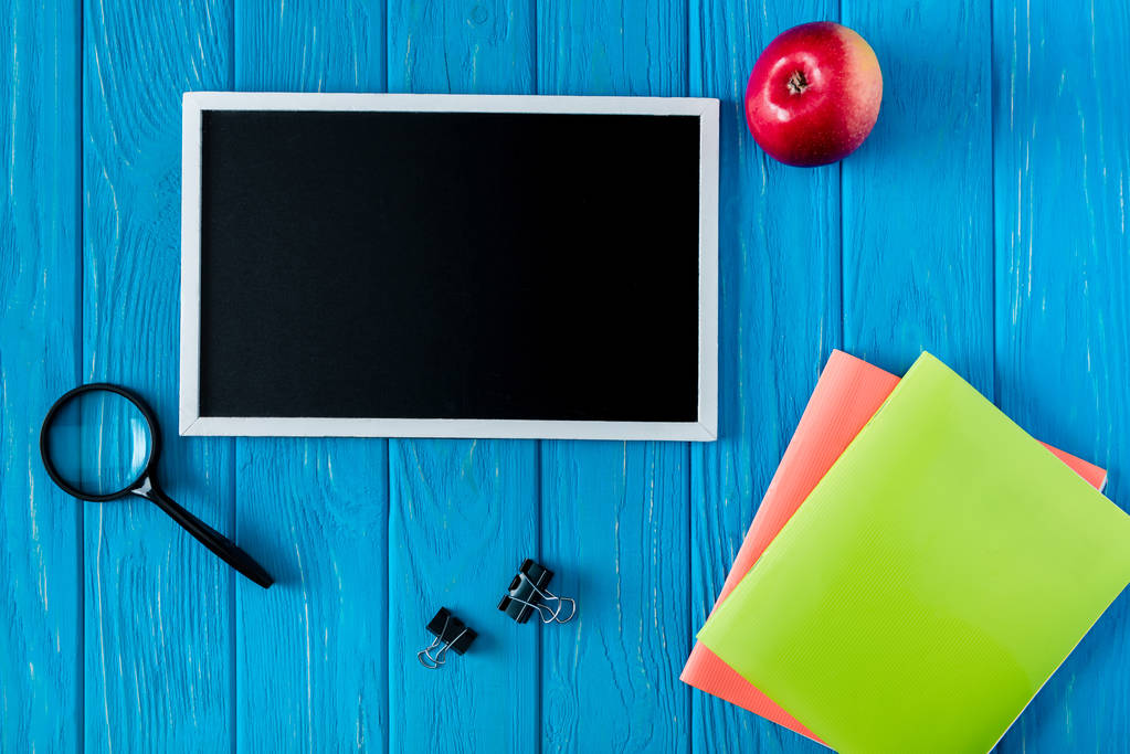 felülnézet üres tábla, apple, papíráru, kék fa háttér  - Fotó, kép