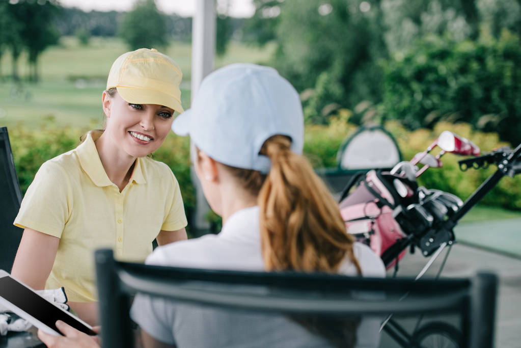 бізнес-партнери з планшетом обговорюють роботу після гри в гольф на полі для гольфу
 - Фото, зображення