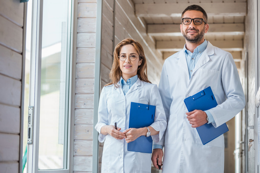 two veterinarians in white coats walking with clipboards in veterinary clinic  - Photo, Image