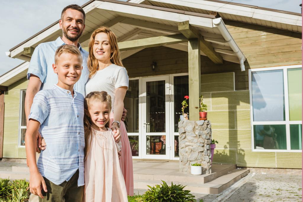 smiling parents and children standing in front of house - Photo, Image