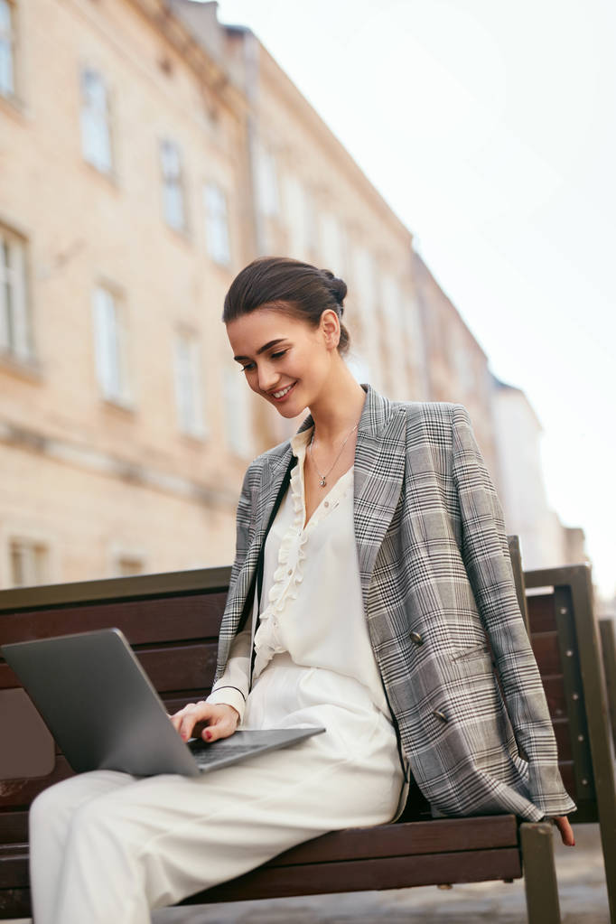 Mujer de negocios trabajando en la computadora en la calle. Chica usando el ordenador portátil al aire libre. Alta resolución
 - Foto, Imagen