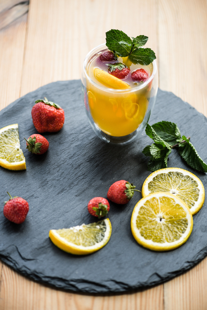 high angle view of fresh delicious summer drink with mint and fruits on slate board  - Photo, Image
