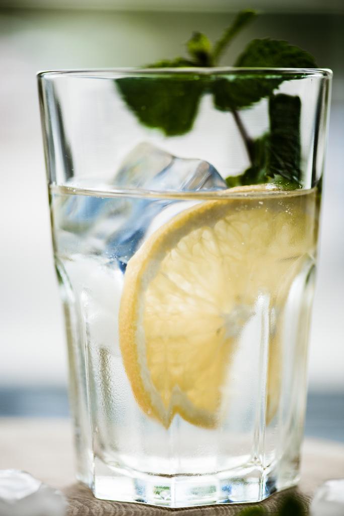 vergrote weergave van verse koude mojito cocktail in glas op tafel  - Foto, afbeelding