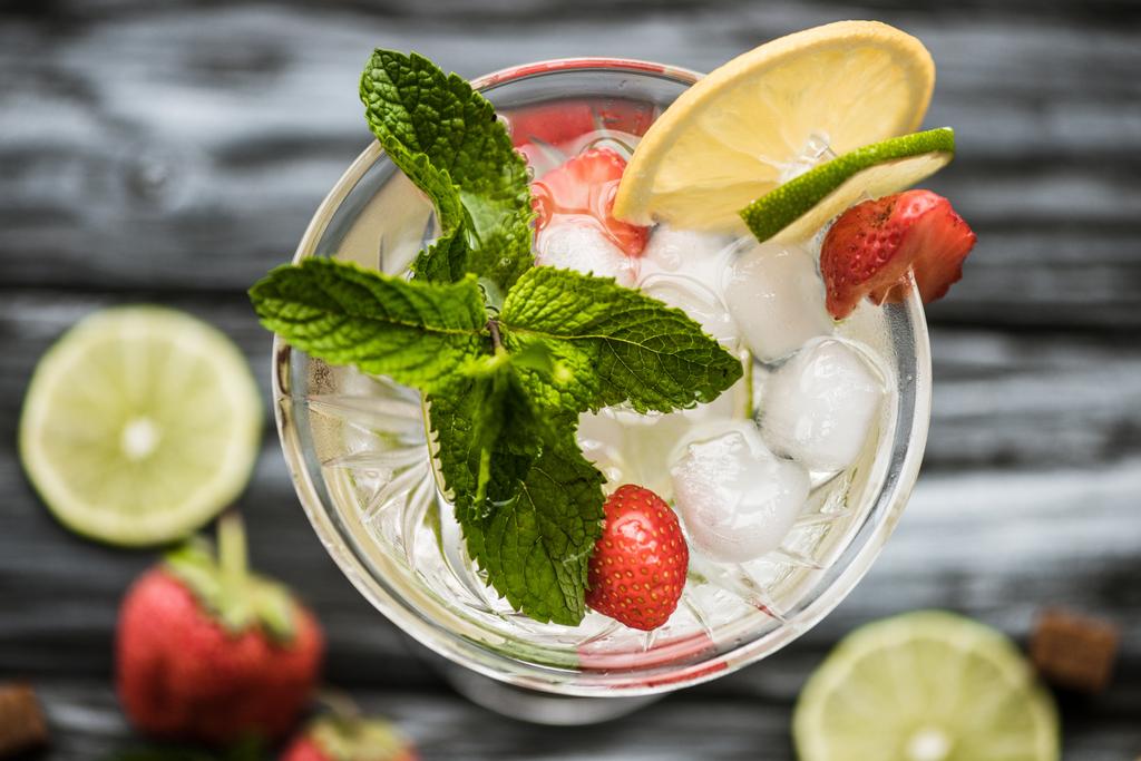 top view of cold strawberry mojito cocktail with mint and ice cubes in glass - Photo, Image