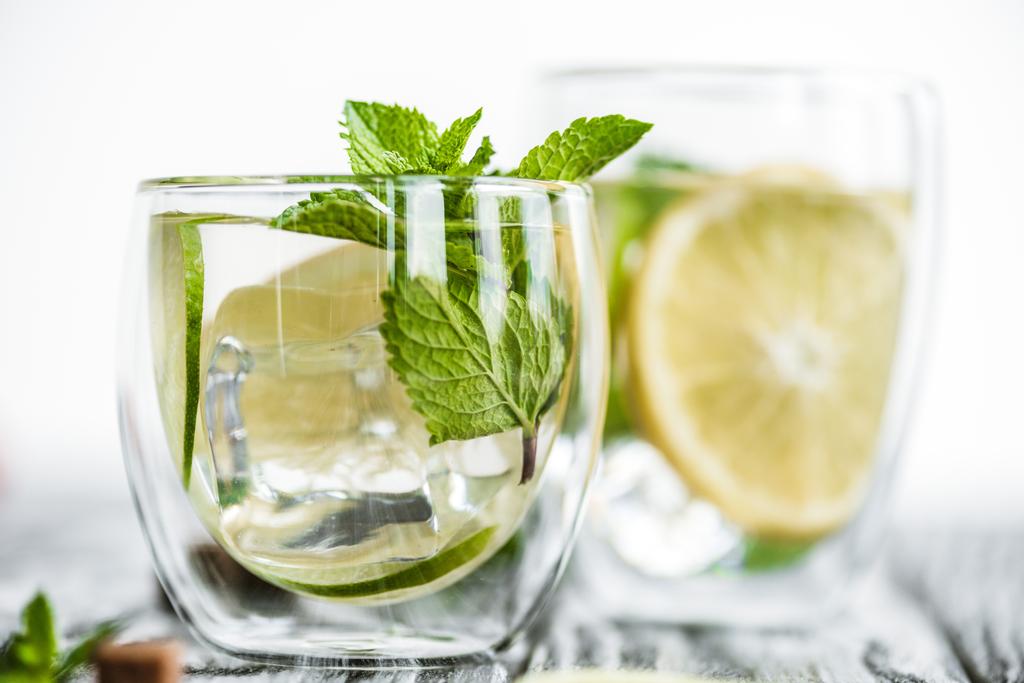 selective focus of fresh cold mojito cocktail in glasses on wooden table  - Photo, Image