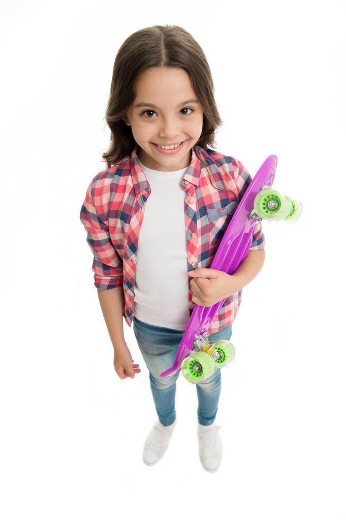 Fond of skateboarding. Niña feliz lleva penny board. A los niños les gusta patinar con una tabla de peniques. Pasatiempo adolescente moderno. Cómo montar en monopatín. Chica cara feliz lleva penny board fondo blanco - Foto, Imagen