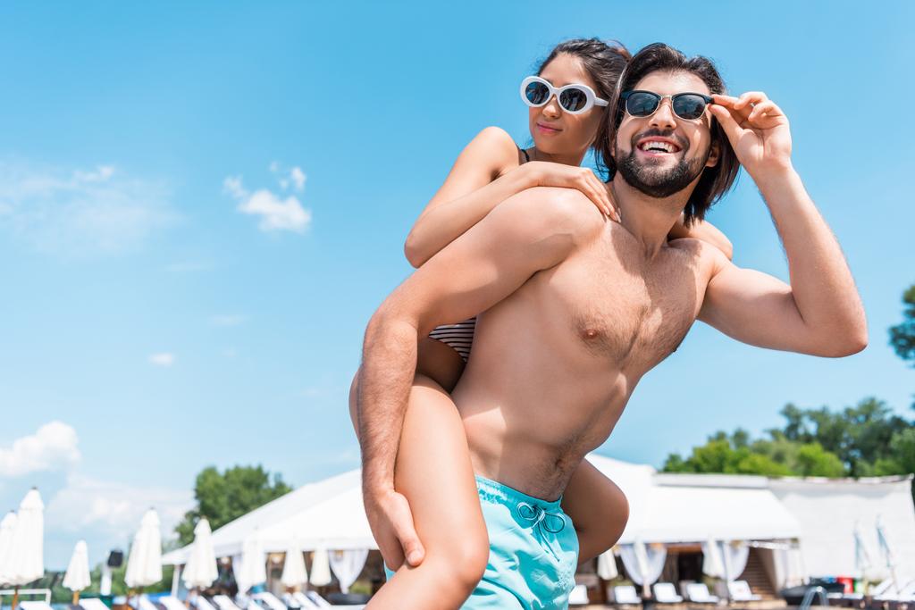bello fidanzato piggybacking la sua ragazza su resort
 - Foto, immagini