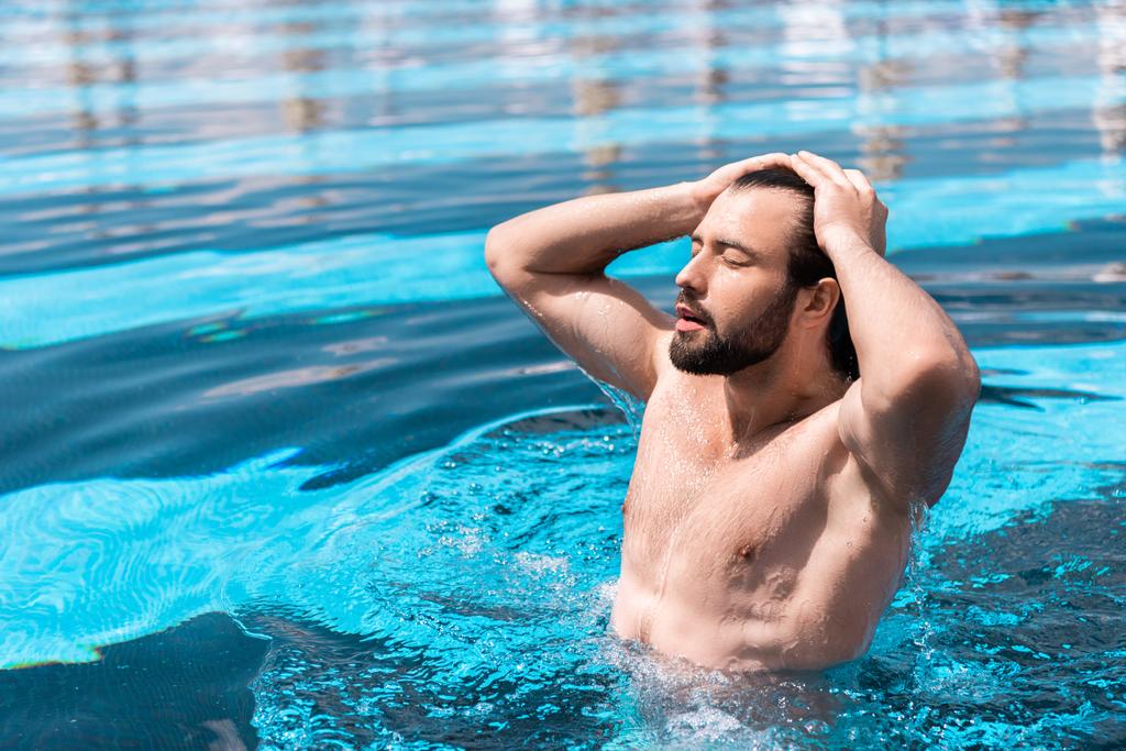 γενειοφόρος άνδρας με κλειστά τα μάτια, στέκεται στην πισίνα  - Φωτογραφία, εικόνα