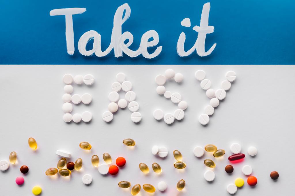 vista superior de letras ter mais fácil feito por pílulas perto de vários comprimidos em fundo colorido
 - Foto, Imagem