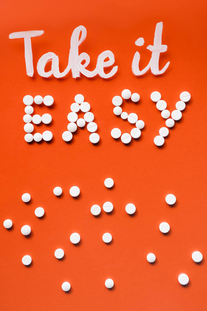 το Top view γραμμάτων πάρτε εύκολο από χάπια λευκό σε κόκκινο φόντο - Φωτογραφία, εικόνα
