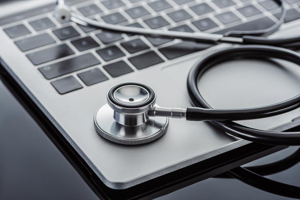 selective focus of stethoscope and laptop on glass surface  - Photo, Image