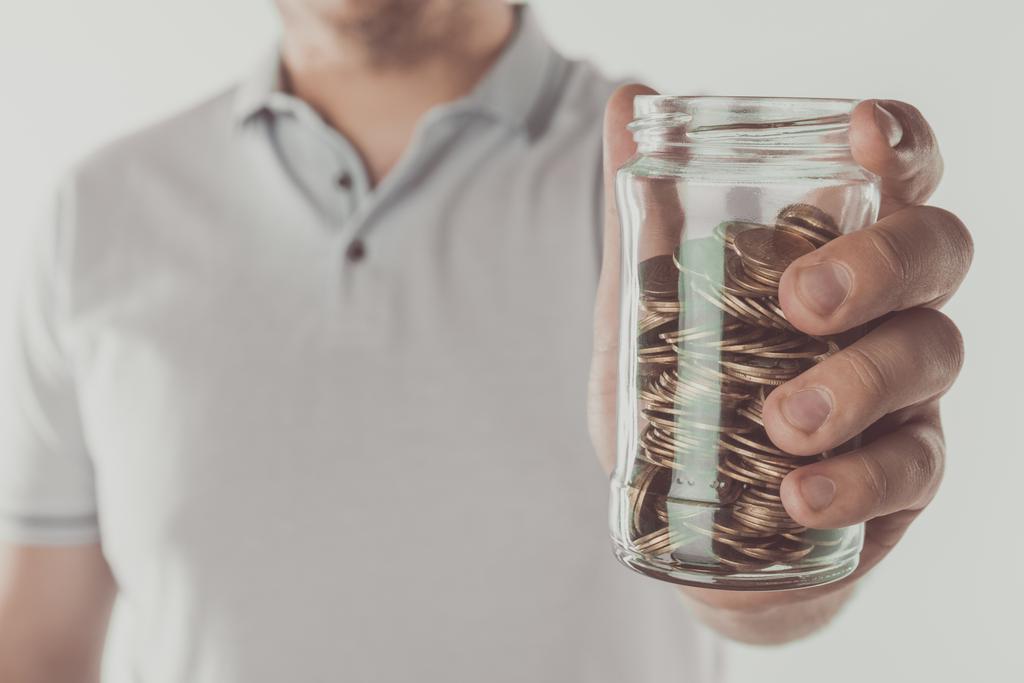 immagine ritagliata di uomo in possesso di vaso di monete isolate su bianco, concetto di risparmio
 - Foto, immagini