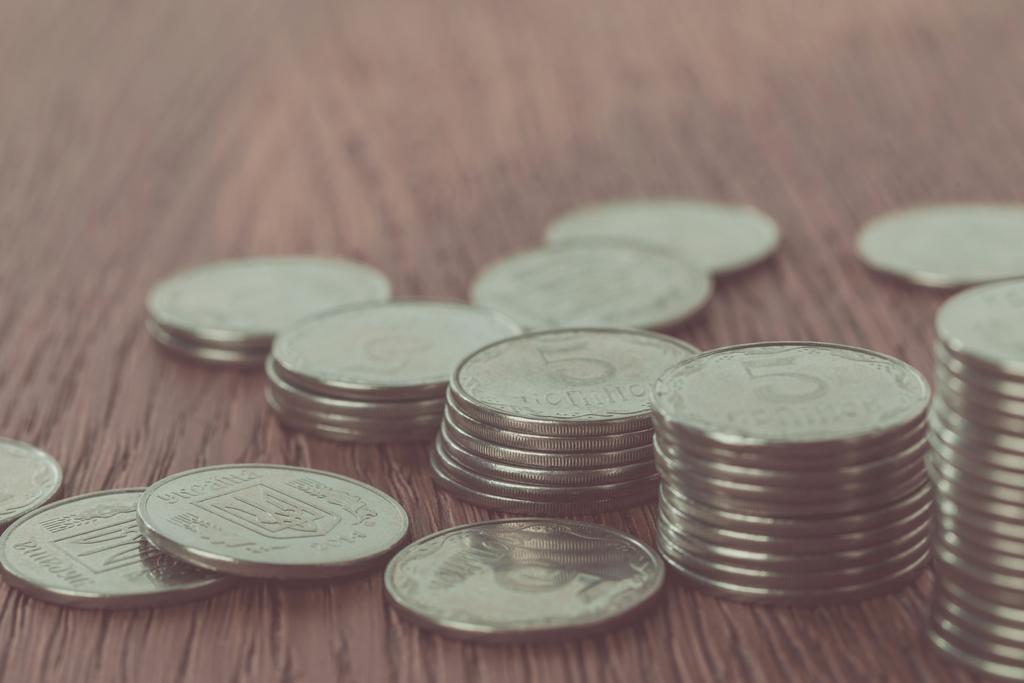 close-up de pilhas de moedas e moedas ucranianas espalhadas em mesa, conceito de poupança
  - Foto, Imagem