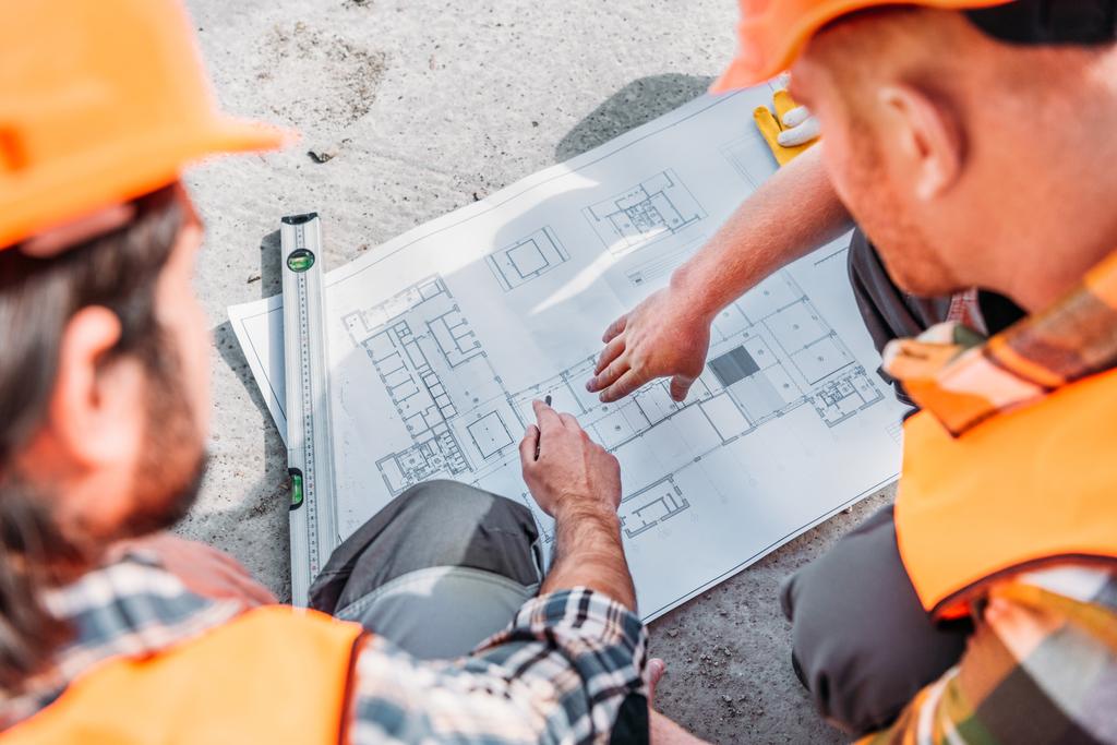 high angle view of builders pointing at blueprint - Photo, Image