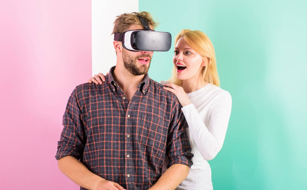 Man VR glasses involved video game while girl try to wake him up. Video game addiction symptoms and treatment. Video game captured imagination of guy. Wife tries to help him back into real life - Photo, Image