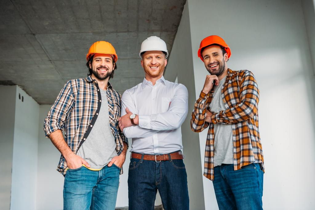 ομάδα αρχιτεκτόνων χαμογελαστός μέσα κατασκευή κτιρίου βλέπουν φωτογραφική μηχανή - Φωτογραφία, εικόνα