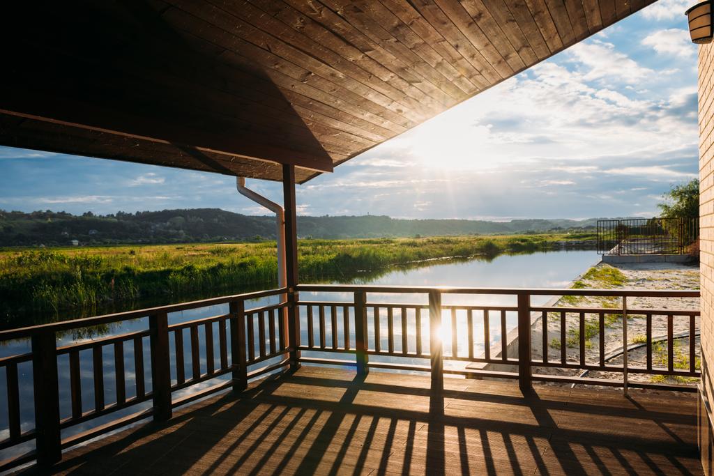 vista do belo pôr do sol sobre o rio a partir de terraço de madeira
 - Foto, Imagem