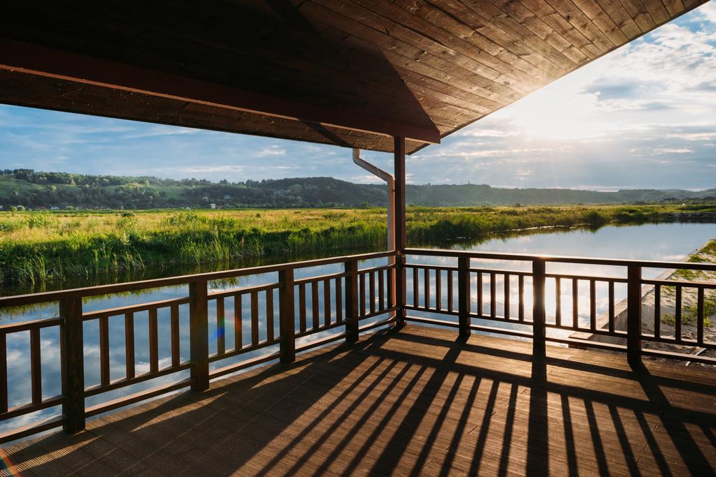 vista panorámica del atardecer sobre el río desde la terraza de madera
 - Foto, Imagen