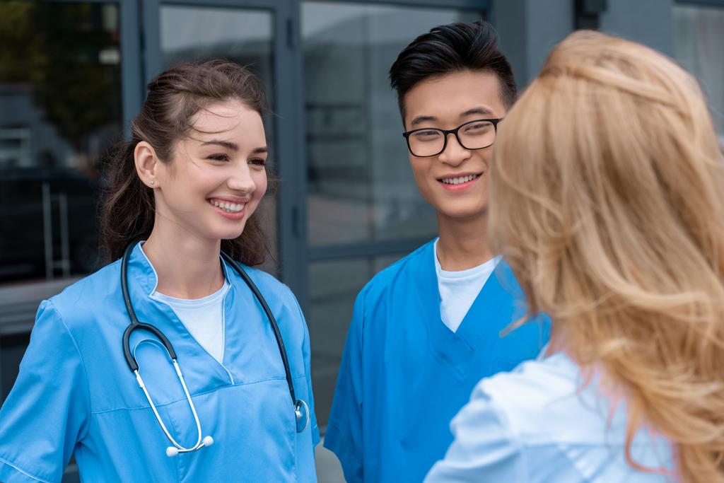 profesor hablando con estudiantes multiculturales sonrientes en la universidad médica
 - Foto, imagen