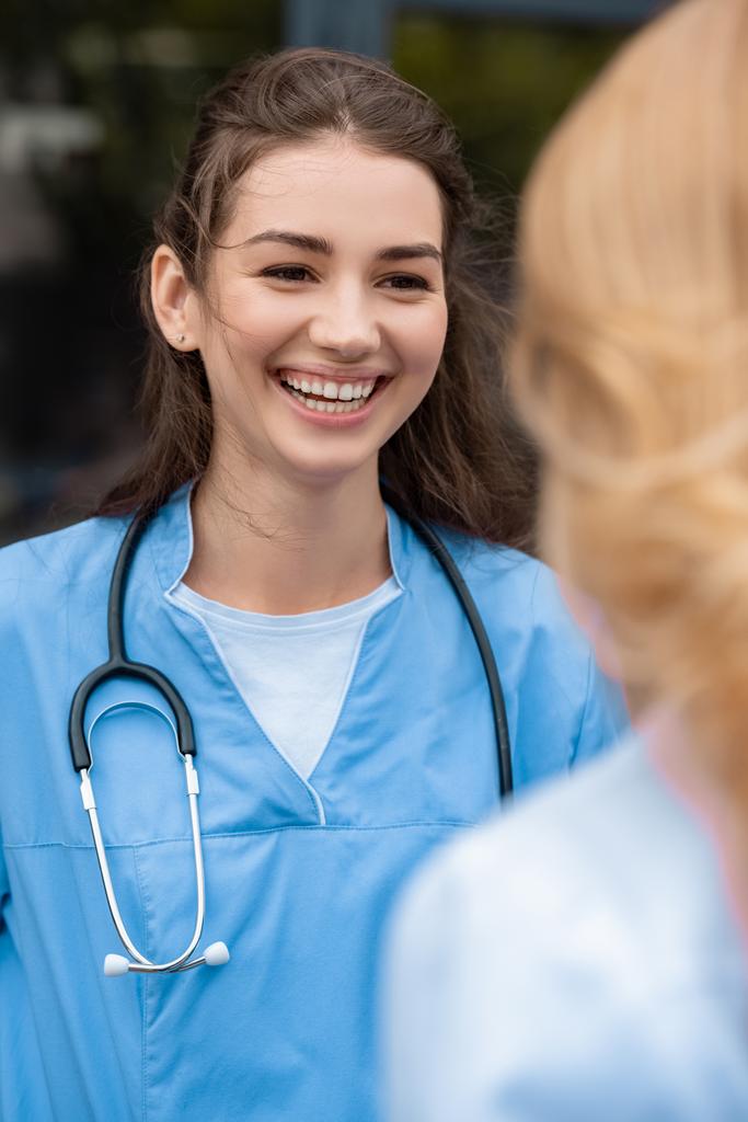 hymyilevä lääketieteen opiskelija puhuu luennoitsijan kanssa
 - Valokuva, kuva