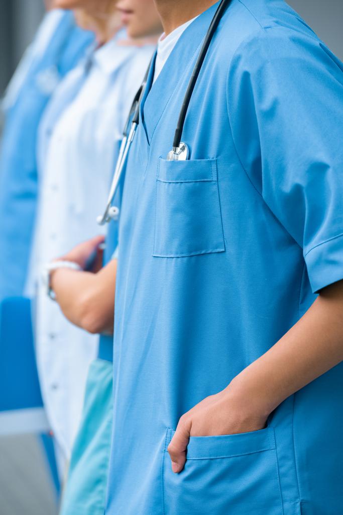 обрезанное изображение студентов-медиков, стоящих в ряду в медицинском университете
 - Фото, изображение