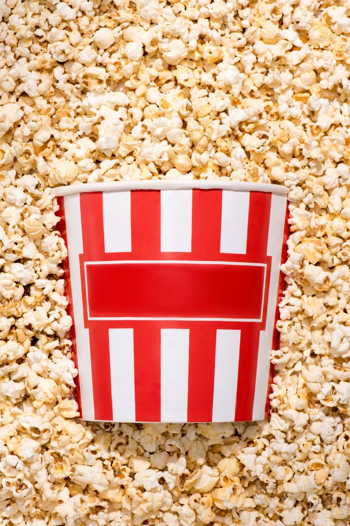 flache Liege mit Einwegeimer und knusprigem Popcorn - Foto, Bild
