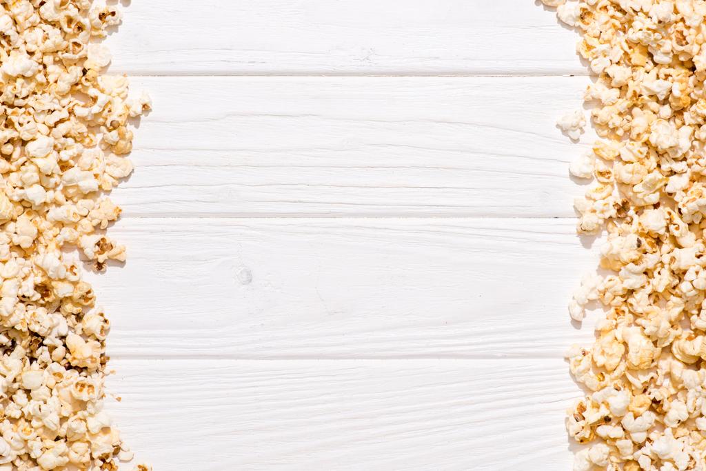 πλήρους καρέ του τοποθετημένα ποπ κορν σχετικά με λευκή ξύλινη επιτραπέζια - Φωτογραφία, εικόνα