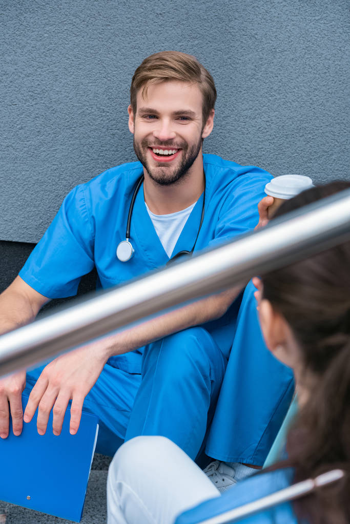 улыбающиеся студенты-медики разговаривают во время кофе-брейка
 - Фото, изображение