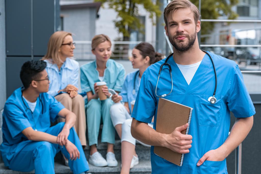 Valkoihoinen mies seisoo monikansallisen opettajan ja opiskelijoiden edessä lääketieteellisessä yliopistossa
 - Valokuva, kuva
