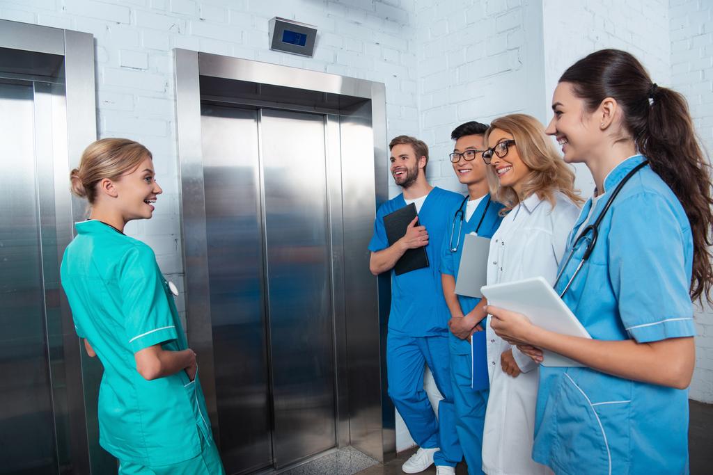 učitel s multikulturní studenty čeká výtah na lékařské univerzitě - Fotografie, Obrázek