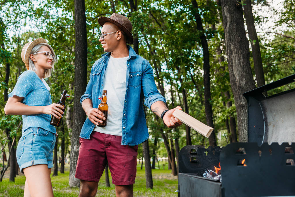 Fröhliches Paar mit Bier setzt Grill im Sommerpark in Brand - Foto, Bild