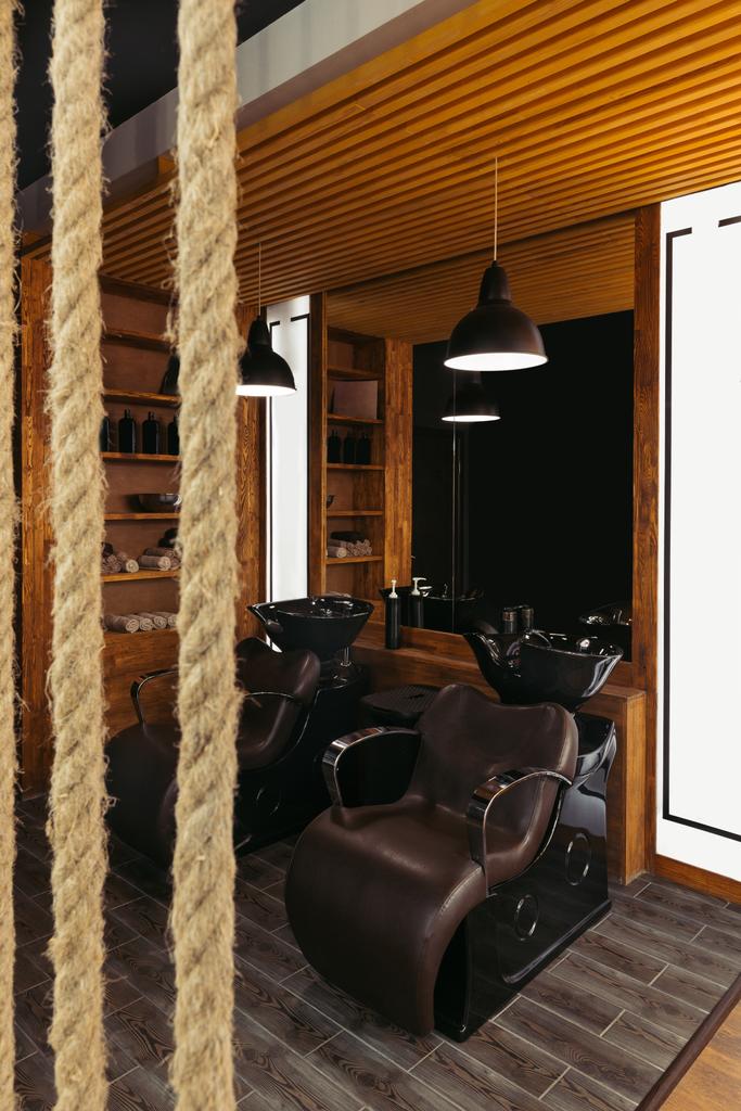 vista ravvicinata di corde e sedie e lavandini in pelle vuota in un moderno barbiere
 - Foto, immagini