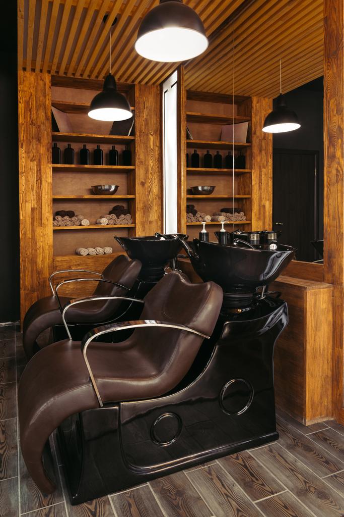 cadeiras de couro vazias e pias no salão de cabeleireiro moderno
 - Foto, Imagem