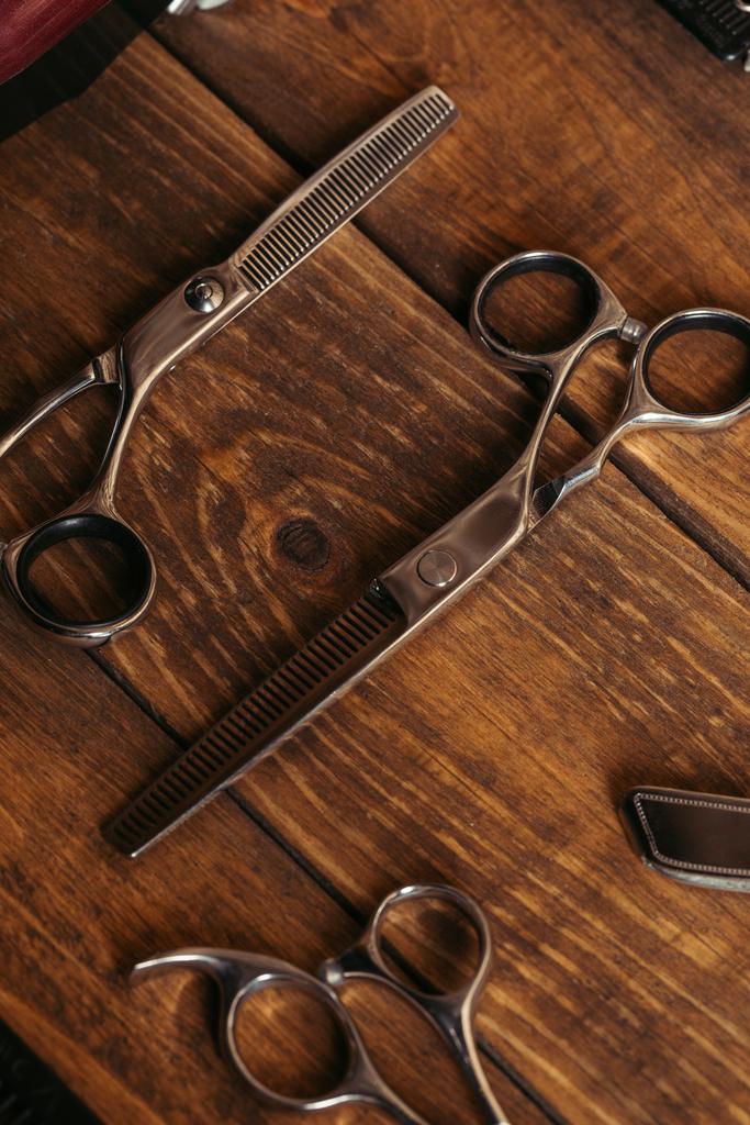 високий кут зору професійних ножиць на дерев'яній поверхні в перукарні
  - Фото, зображення