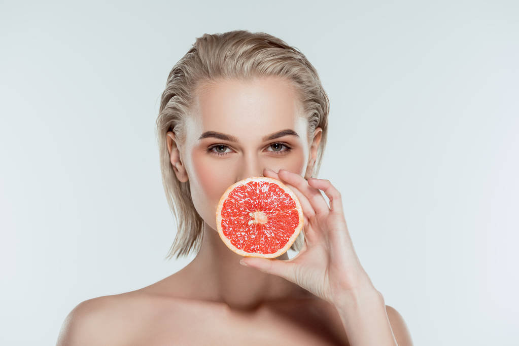 привлекательная женщина, позирующая с грейпфрутом, изолированная на сером
 - Фото, изображение