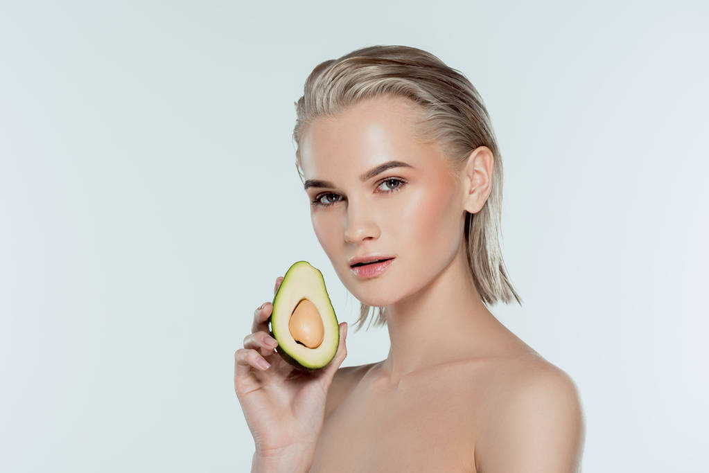 beautiful young woman posing with avocado, isolated on grey - Photo, Image