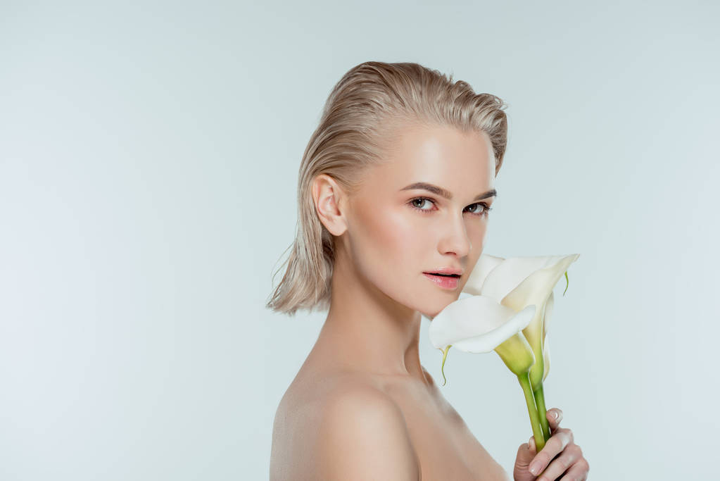 портрет красивой блондинки, позирующей с цветами каллы, изолированной на серой, природной красоте
 - Фото, изображение