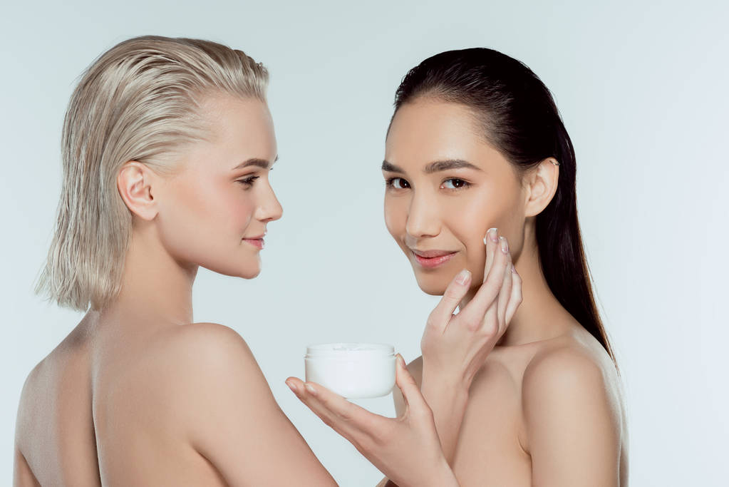 multiethnic nude girls applying face cream, isolated on grey, skin care concept - Photo, Image