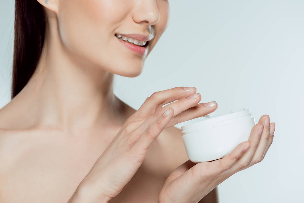 cropped view of woman applying face cream, isolated on grey - Photo, Image