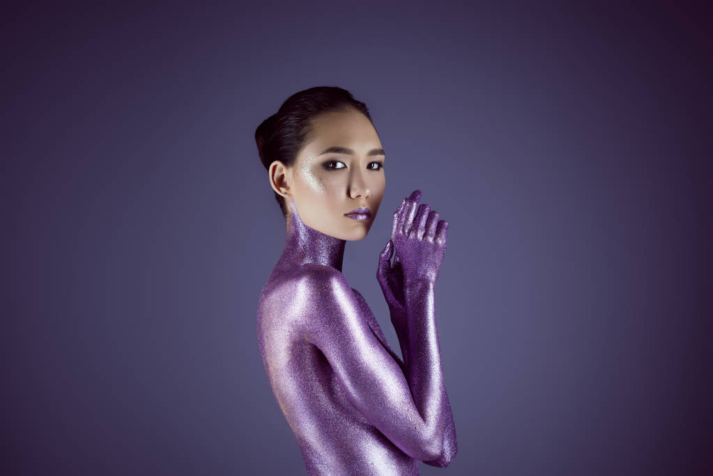 привлекательная обнаженная модная азиатка в ультрафиолетовом блеске, изолированная на фиолетовом
 - Фото, изображение