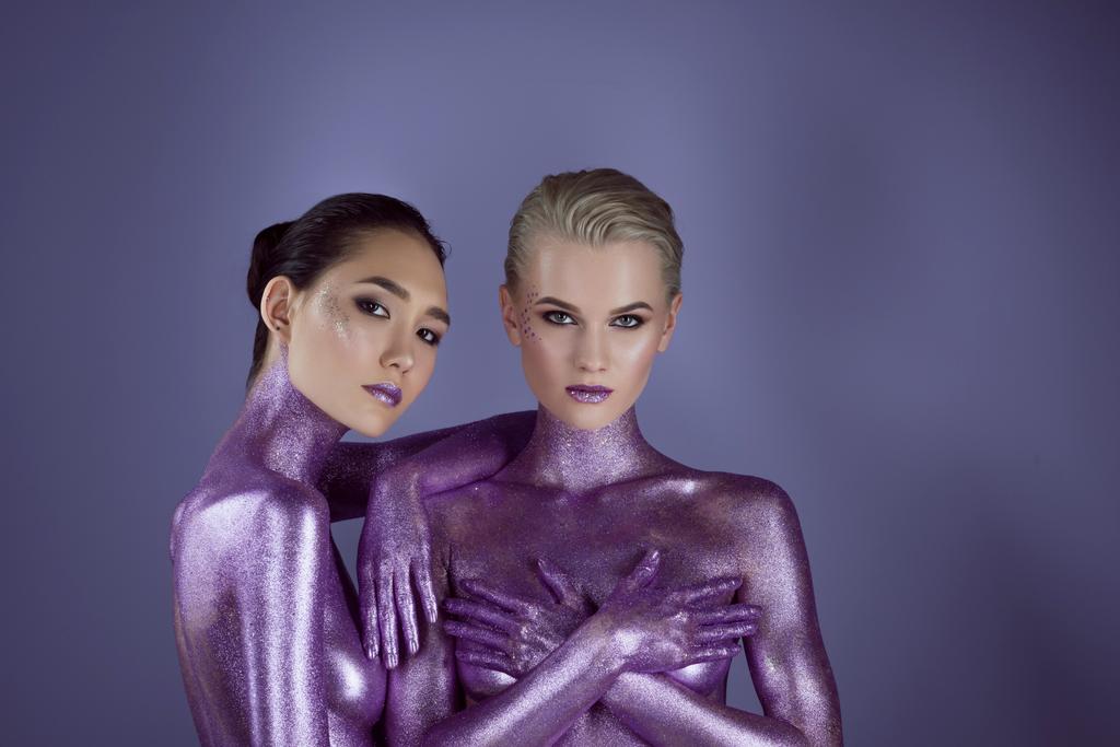 fashionable multicultural girls in purple glitter, isolated on violet - Photo, Image