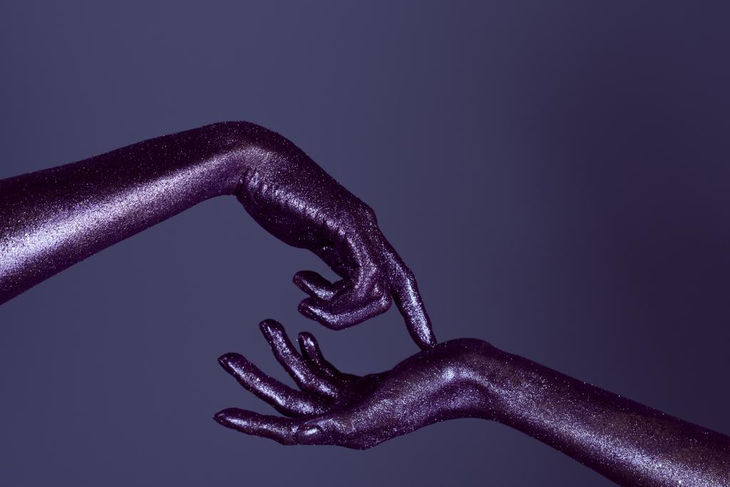 vista cortada de mãos macias em brilho tocando uns aos outros com os dedos, isolados em roxo
 - Foto, Imagem