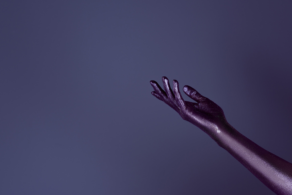 a női kéz a ultra violet csillogó, lila elszigetelt levágott megtekintése - Fotó, kép
