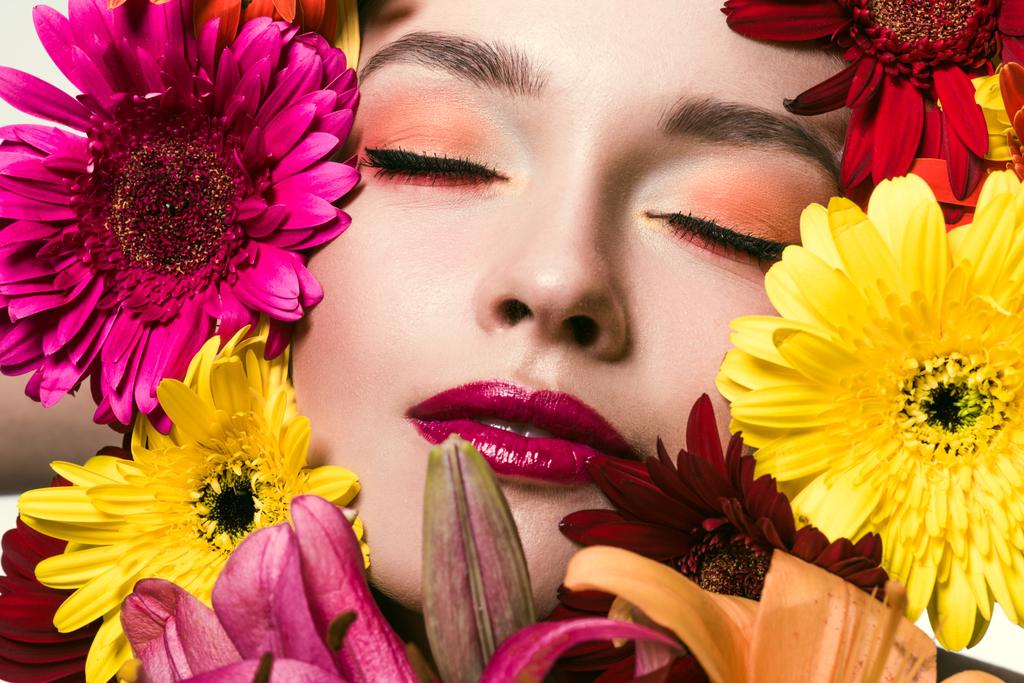 close-up retrato de bela jovem com olhos fechados cercados de várias flores
 - Foto, Imagem