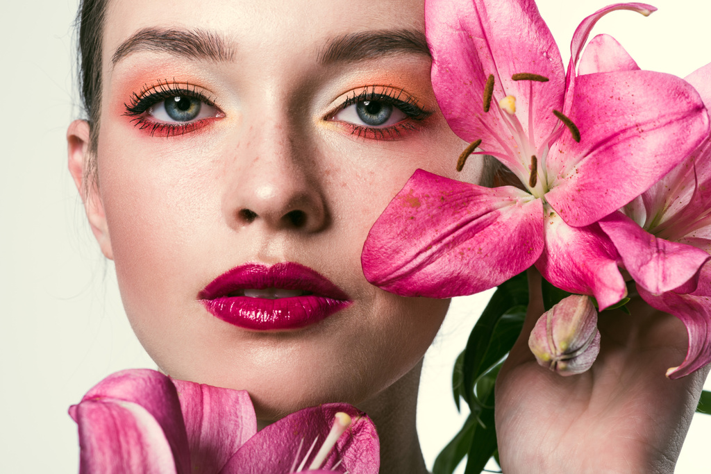 крупным планом портрет красивой молодой женщины с розовыми лилиями, изолированными на белом
 - Фото, изображение