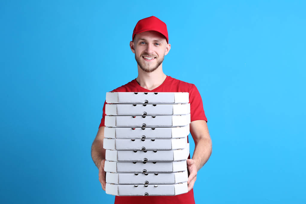 Uomo di consegna con pizza su sfondo blu
 - Foto, immagini