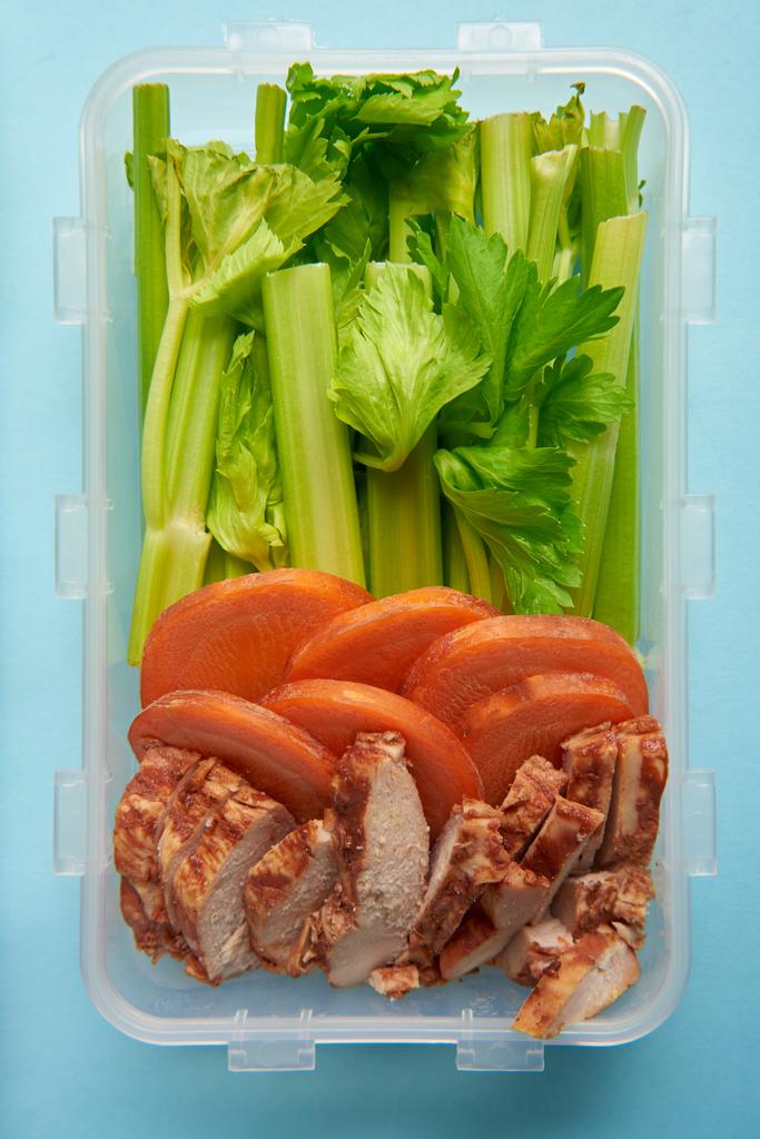 top view of food container full of healthy food on blue backdrop - Photo, Image