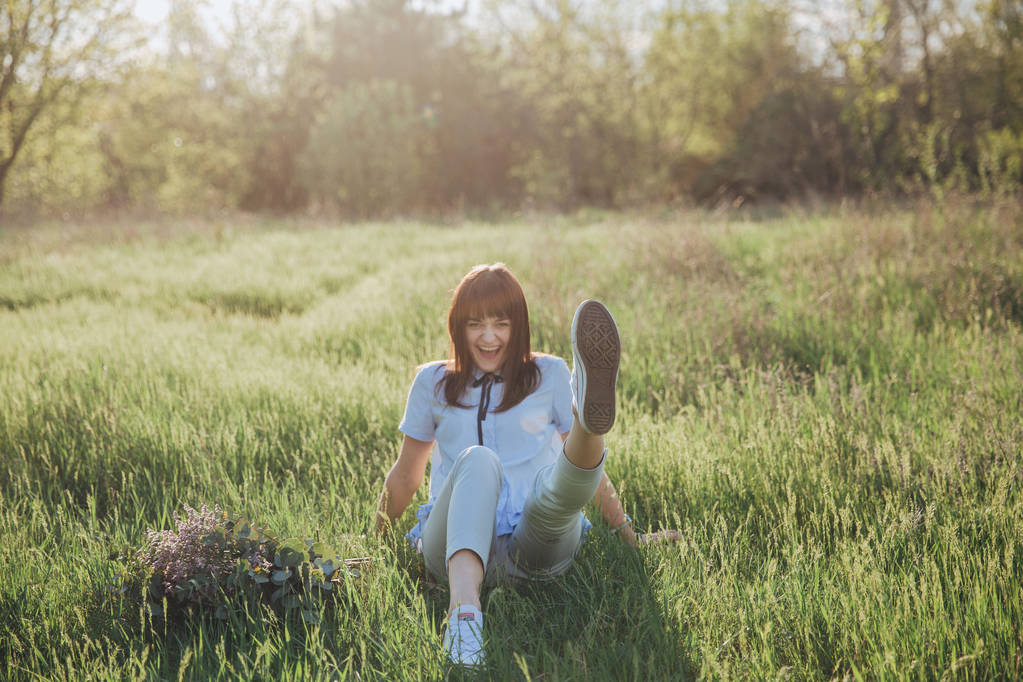 sorrindo menina engraçada com o buquê rústico no fundo do campo de primavera
 - Foto, Imagem