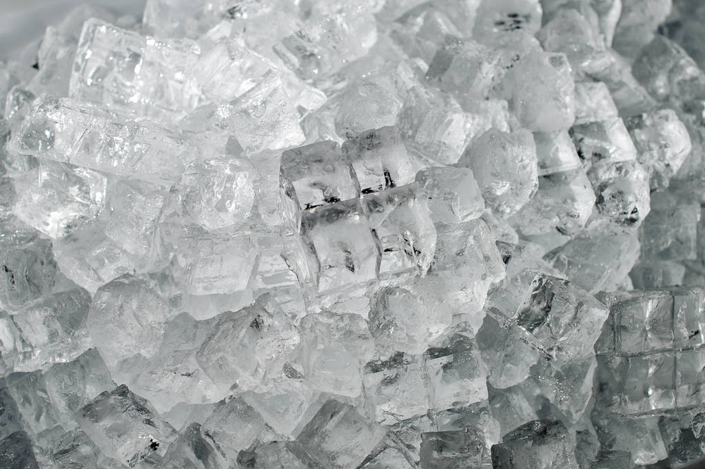 Fondo texturizado de un pequeño cubo de hielo transparente acostado en el montón de la planta de producción de hielo
 - Foto, imagen