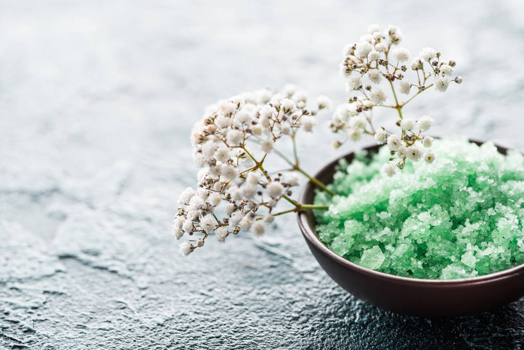vue rapprochée du sel de mer vert dans un bol et des petites fleurs blanches, mise au point sélective
 - Photo, image
